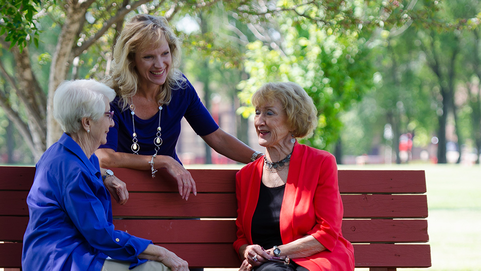 women talking on park bench