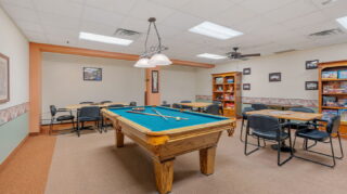 Billiards room with pool table and seating area at Apple Valley Village.