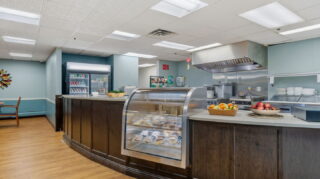 Cafe counter with food display and kitchen area at Apple Valley Village.