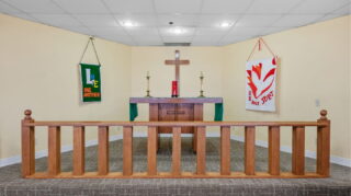 Chapel altar with cross, worship decor, and seating at Apple Valley Village.