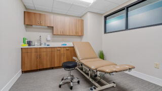 Exam room with treatment table and cabinets at Apple Valley Village.