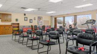 Fitness center with exercise equipment and group seating area at Apple Valley Village.
