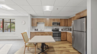 Health care center kitchen with appliances and seating at Apple Valley Village.