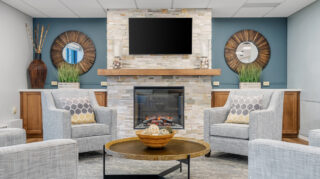 Health care center lounge with fireplace and seating at Apple Valley Village.