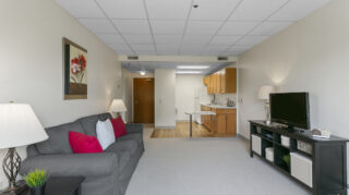Living room with sofa and television at Apple Valley Village.