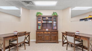 Comfortable lounge and sitting area with desks and shared workspace at Apple Valley Village.