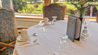 Dining room table setting with place settings and window views at Apple Valley Village.