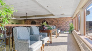 Comfortable lounge and sitting area with upholstered chairs and natural light at Apple Valley Village.