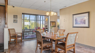 Memory care dining area with tables and seating at Apple Valley Village.