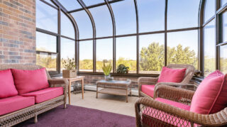 Memory care sunroom with seating and large windows at Apple Valley Village.