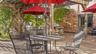 Outdoor patio dining area with umbrellas and seating at Apple Valley Village.