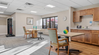 Therapy activity space with tables and equipment at Apple Valley Village.