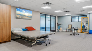 Therapy room with treatment table and equipment at Apple Valley Village.
